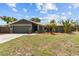 Charming single-story home featuring a well-maintained lawn, mature tropical landscaping, and a two-car garage at 6921 8Th Street E Ct, Sarasota, FL 34243
