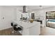 Modern kitchen island with stylish stools and stainless steel appliances near an outdoor pool view at 6921 8Th Street E Ct, Sarasota, FL 34243