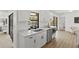 Bright kitchen with stainless steel appliances, white cabinets, and a window overlooking the pool area at 6921 8Th Street E Ct, Sarasota, FL 34243