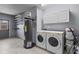 Functional laundry room with efficient appliances, storage cabinets, and convenient shelving at 6921 8Th Street E Ct, Sarasota, FL 34243