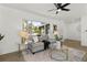 Sunlit living room featuring a comfortable couch, stylish decor, and large window with a lush view at 6921 8Th Street E Ct, Sarasota, FL 34243