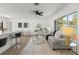 Bright living room featuring white walls, wood floors, and comfortable seating near large windows at 6921 8Th Street E Ct, Sarasota, FL 34243
