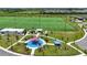 Aerial view of the playground and sports field with parking area and sidewalks, lush green landscaping and palm trees at 7420 Paradiso Dr, Apollo Beach, FL 33572