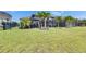 Well-manicured lawn with tropical landscaping, screened lanai and black fencing for privacy at 7420 Paradiso Dr, Apollo Beach, FL 33572