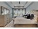 Bedroom with blue accent wall, tray ceiling, plantation shutters, and gray area rug at 7420 Paradiso Dr, Apollo Beach, FL 33572