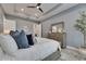 Bedroom featuring a tray ceiling, light walls, and wood dresser with mirror at 7420 Paradiso Dr, Apollo Beach, FL 33572