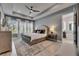 Spacious bedroom showcasing a tray ceiling, plantation shutters, and ensuite bathroom at 7420 Paradiso Dr, Apollo Beach, FL 33572