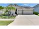Charming home with a two-car garage, manicured lawn, palm trees, and beautiful landscaping at 7420 Paradiso Dr, Apollo Beach, FL 33572