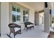 Inviting front porch with chairs, showcasing a relaxing outdoor space, windows and lush landscaping at 7420 Paradiso Dr, Apollo Beach, FL 33572