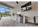 Outdoor kitchen equipped with a grill and mini-fridge near a pool at 7420 Paradiso Dr, Apollo Beach, FL 33572
