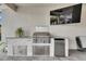 An outdoor kitchen features a built-in grill, mini refrigerator and a flatscreen television at 7420 Paradiso Dr, Apollo Beach, FL 33572