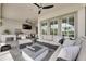 Spacious outdoor patio with comfortable furniture, fire pit, outdoor kitchen, and ceiling fans at 7420 Paradiso Dr, Apollo Beach, FL 33572