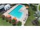 Aerial view of community pool featuring lounge chairs, colorful umbrellas, and mature landscaping at 7420 Paradiso Dr, Apollo Beach, FL 33572