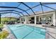 An enclosed pool offers ample seating, dining area, outdoor kitchen, and lounge seating for relaxation at 7420 Paradiso Dr, Apollo Beach, FL 33572