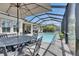 The enclosed pool area is complemented by dining under an umbrella and additional outdoor lounge seating at 7420 Paradiso Dr, Apollo Beach, FL 33572