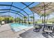 Enclosed pool area featuring dining under an umbrella and lush landscaping for a private outdoor experience at 7420 Paradiso Dr, Apollo Beach, FL 33572