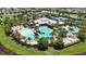 Aerial view of the community pool, with a zero entry pool, waterslide, covered seating and tennis courts at 7420 Paradiso Dr, Apollo Beach, FL 33572