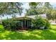 Backyard view of the home, showing screened in porch and landscaping at 8626 Woodbridge Dr, New Port Richey, FL 34655