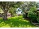 Backyard view of the lawn, landscaping, and houses nearby at 8626 Woodbridge Dr, New Port Richey, FL 34655