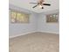 This bedroom has two windows, tan tile, and a ceiling fan with lighting at 8626 Woodbridge Dr, New Port Richey, FL 34655