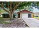 Traditional home exterior with a 2-car garage and mature trees at 8626 Woodbridge Dr, New Port Richey, FL 34655