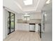 Open kitchen area features modern appliances, white cabinets, and a view to the outside through sliding glass doors at 8626 Woodbridge Dr, New Port Richey, FL 34655