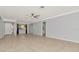 Large living room with ceiling fan, neutral paint, and doorway to bathroom at 8626 Woodbridge Dr, New Port Richey, FL 34655