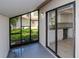 A screened porch offers a view of the yard and kitchen with sliding glass door at 8626 Woodbridge Dr, New Port Richey, FL 34655