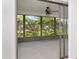 The sliding glass doors allow access to the screened porch with a ceiling fan at 8626 Woodbridge Dr, New Port Richey, FL 34655