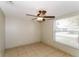 Neutral bedroom features tile flooring, ceiling fan, and window with blinds at 8804 Lido Ln, Port Richey, FL 34668