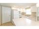 Well-lit kitchen featuring white appliances, cabinets and countertops, along with tile flooring at 8804 Lido Ln, Port Richey, FL 34668
