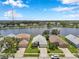 Aerial view of homes along a lake in a tranquil neighborhood with lush greenery and blue skies at 899 Addison Ne Dr, St Petersburg, FL 33716