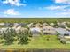 Aerial view showcasing a neighborhood with well-maintained homes, lush greenery, and a serene lake at 899 Addison Ne Dr, St Petersburg, FL 33716