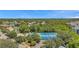 Aerial view of a tennis court, a community pool and clubhouse surrounded by mature trees and landscaping at 899 Addison Ne Dr, St Petersburg, FL 33716