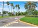 View of the well-manicured community entrance with lush landscaping and mature palm trees at 899 Addison Ne Dr, St Petersburg, FL 33716