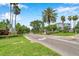 Landscaped community entrance with mature palm trees and well-maintained signage along a paved road at 899 Addison Ne Dr, St Petersburg, FL 33716