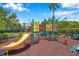 Community playground with colorful slide and climbing structure in mulched area at 899 Addison Ne Dr, St Petersburg, FL 33716