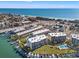 Breathtaking aerial view of waterfront condos, marina, and sandy beach with turquoise ocean waters at 9755 Harrell Ave # 101, Treasure Island, FL 33706
