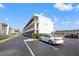 Exterior shot of the building with balconies, a well-maintained parking area, and landscaping at 9755 Harrell Ave # 101, Treasure Island, FL 33706