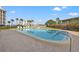 Inviting outdoor pool area surrounded by lush landscaping and palm trees with nearby condos at 9755 Harrell Ave # 101, Treasure Island, FL 33706
