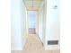 A hallway with a closet, tile flooring, view to another room, and white walls at 101 Cambridge Trl # 194, Sun City Center, FL 33573