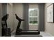 Inviting exercise room featuring a treadmill, weights, and natural light from the window at 10198 Trumpet Honeysuckle Way, San Antonio, FL 33576