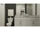 Bathroom featuring double vanity, with white cabinets, a toilet and modern decor at 10203 Trumpet Honeysuckle Way, San Antonio, FL 33576