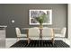 Elegant dining area features a modern wood table, comfortable seating, and stylish artwork, perfect for entertaining at 10203 Trumpet Honeysuckle Way, San Antonio, FL 33576