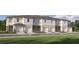Charming townhome exterior showcasing attached garages and well-maintained landscaping, inviting curb appeal at 10203 Trumpet Honeysuckle Way, San Antonio, FL 33576