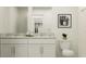 Bright bathroom showcasing double sinks, granite countertops, and ample storage in the cabinets and shelving at 10211 Trumpet Honeysuckle Way, San Antonio, FL 33576