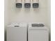 Efficient laundry room with modern washer and dryer, plus wire shelving for organized storage of essentials at 10211 Trumpet Honeysuckle Way, San Antonio, FL 33576