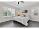 Bright bedroom with a queen bed, dark floors, large windows and decor at 106 Cutlass Way, Oldsmar, FL 34677