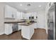 Modern kitchen featuring white cabinets, granite countertops, stainless steel appliances, and a center island at 106 Cutlass Way, Oldsmar, FL 34677