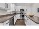 Modern kitchen featuring white cabinets, granite countertops, stainless steel appliances, and a center island at 106 Cutlass Way, Oldsmar, FL 34677